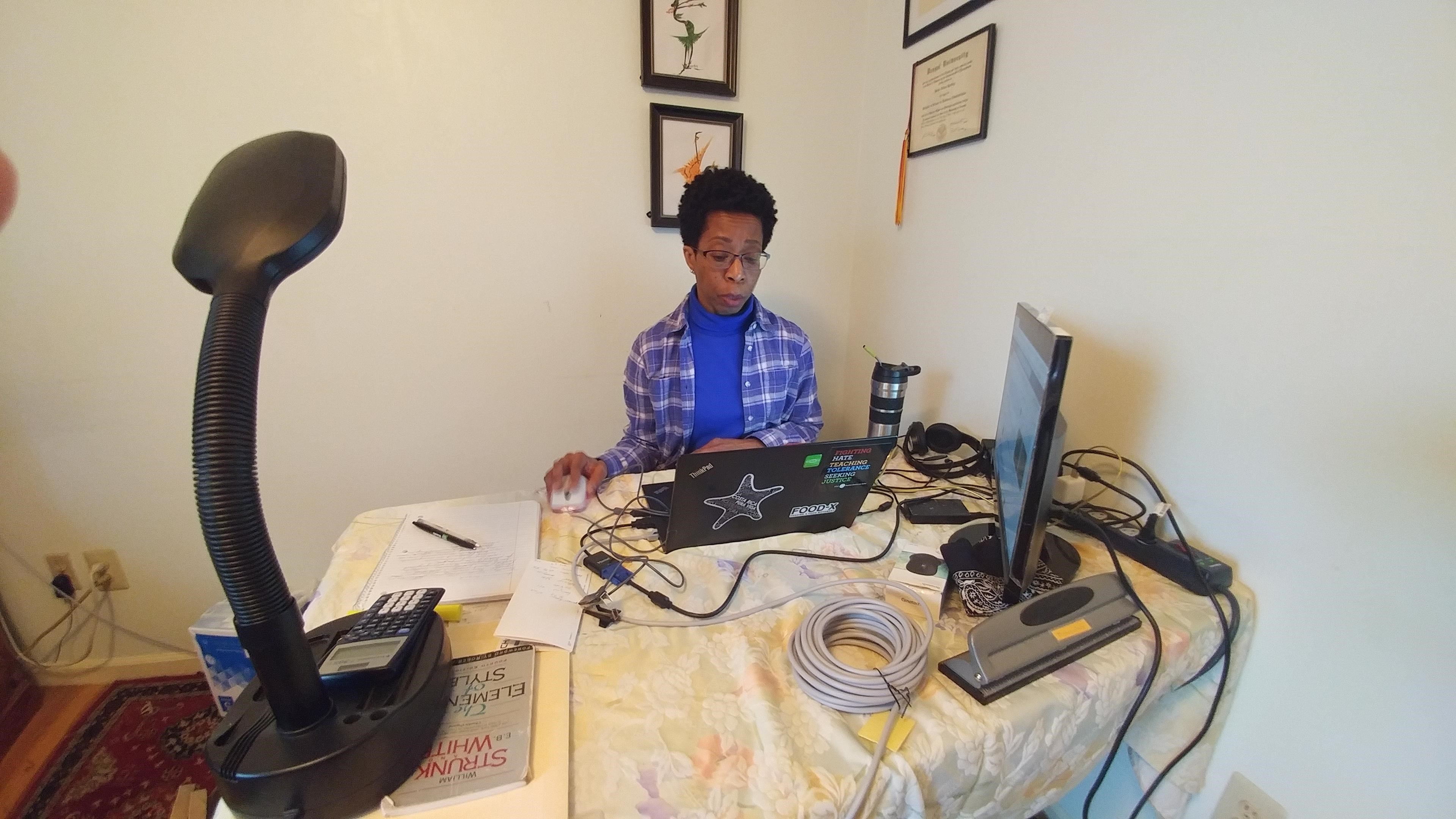 A woman works at a desk with a laptop